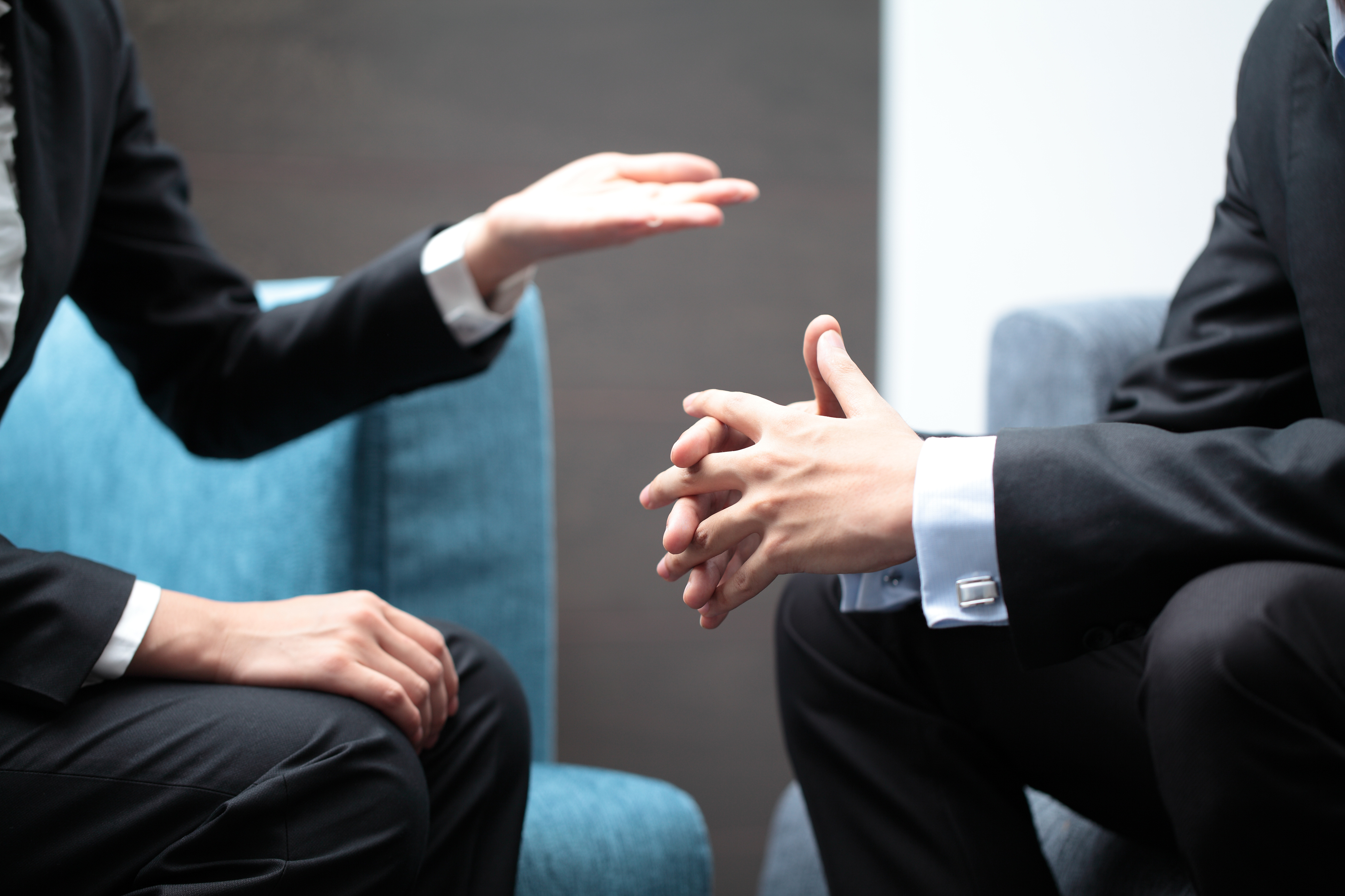 Hand gestures of a businesswoman and businessman in meeting.