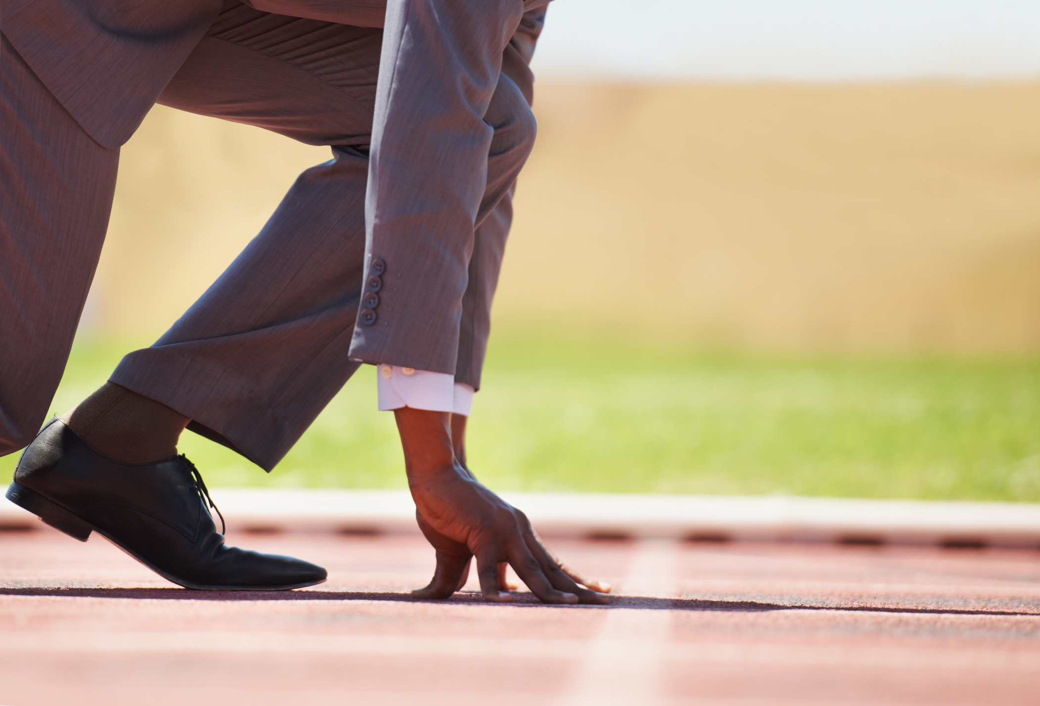 A businessman on a track ready to run