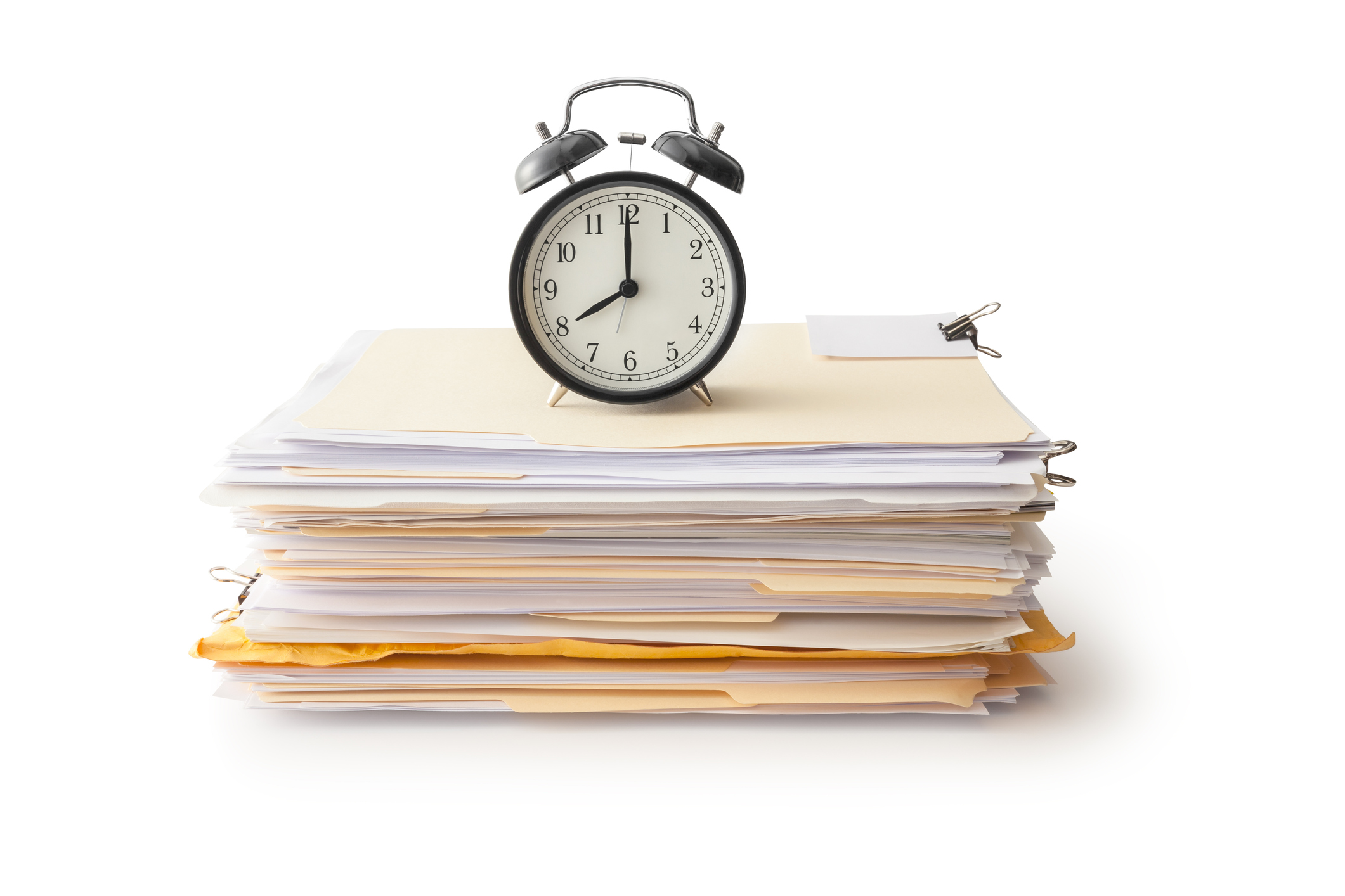 Clock sitting on top of a pile of work papers.