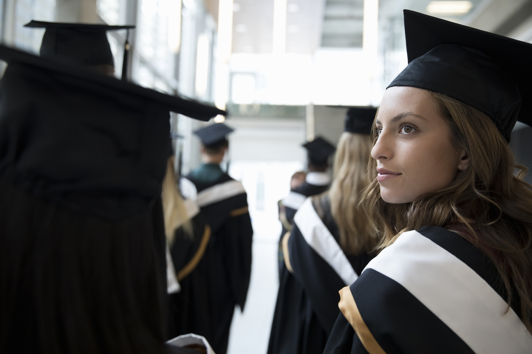 Serious, confident female college student graduate in cap and gown