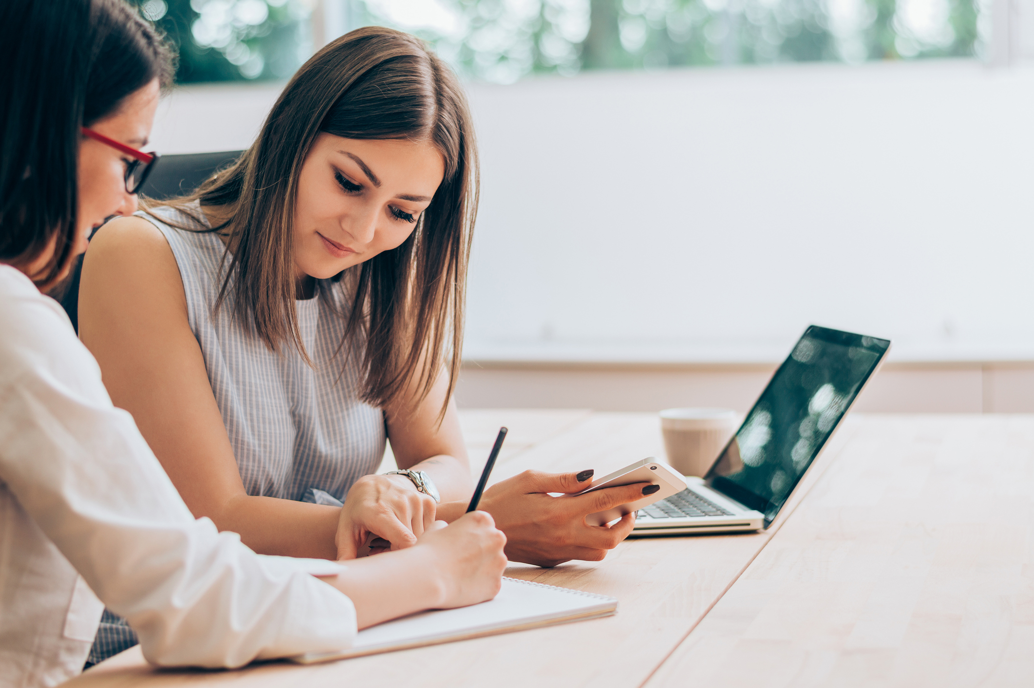 Two female colleagues in office working together.