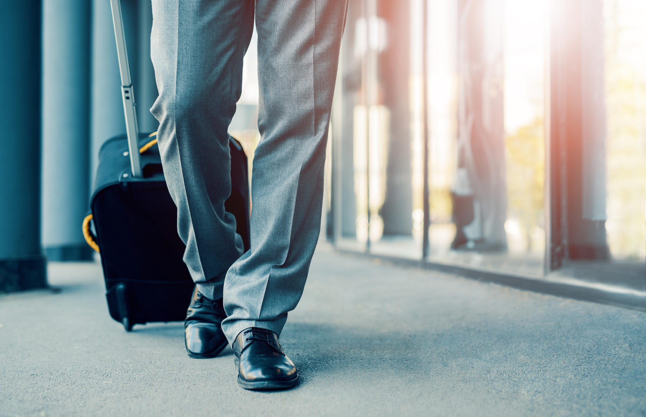 A person rolling a suitcase at the airport