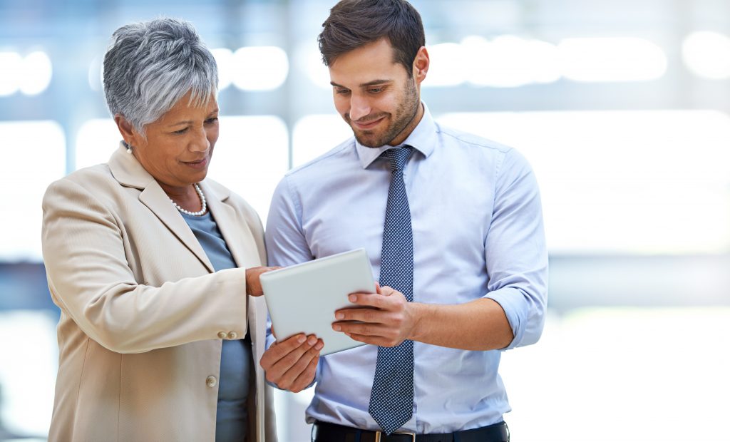 Two business people discussing a transaction using a tablet.