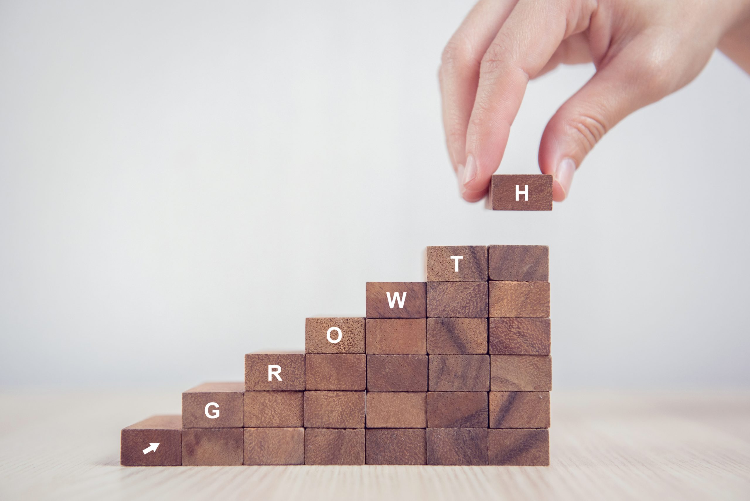 How to scale your sales program. Blocks stacked up spelling out growth.