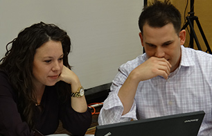 Two team members training together on a computer