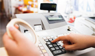 Photo of a person's hand using a retail cash register.